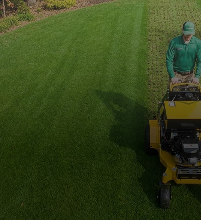 Virginia Green employee aerating and seeding a lawn